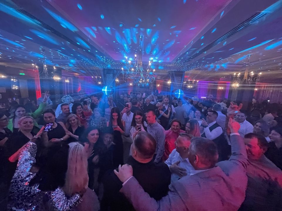 Ring de dans plin de invitați la o petrecere de nuntă, lumini albastre și roz sub candelabre, Sibiu